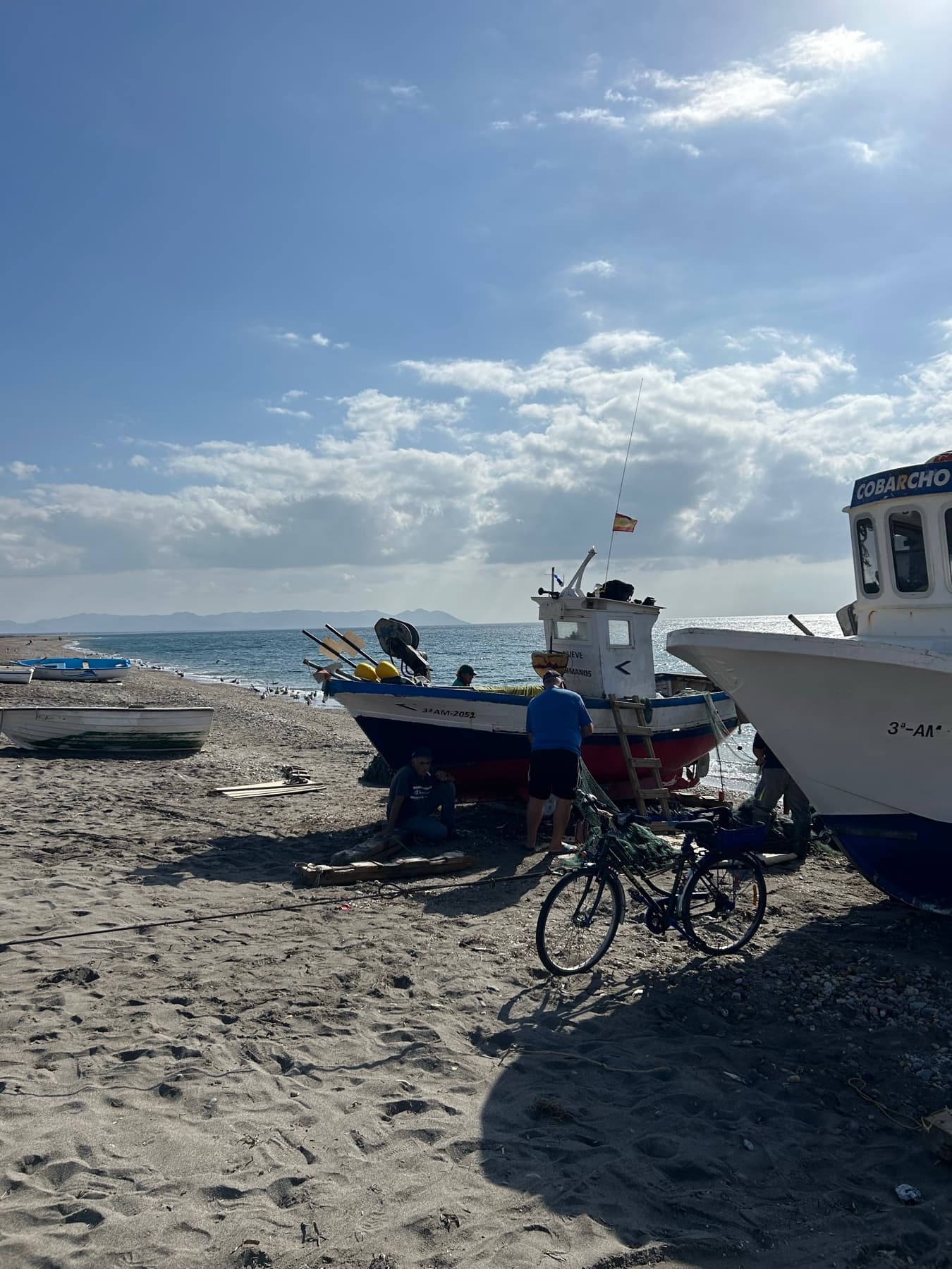 Bicycle on the beach beside fishing boats