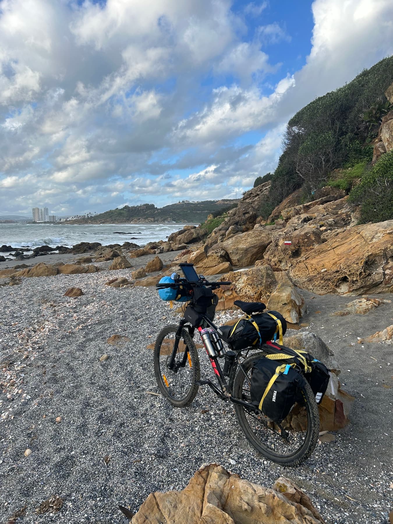 Loaded bicycle beside a rocky cove
