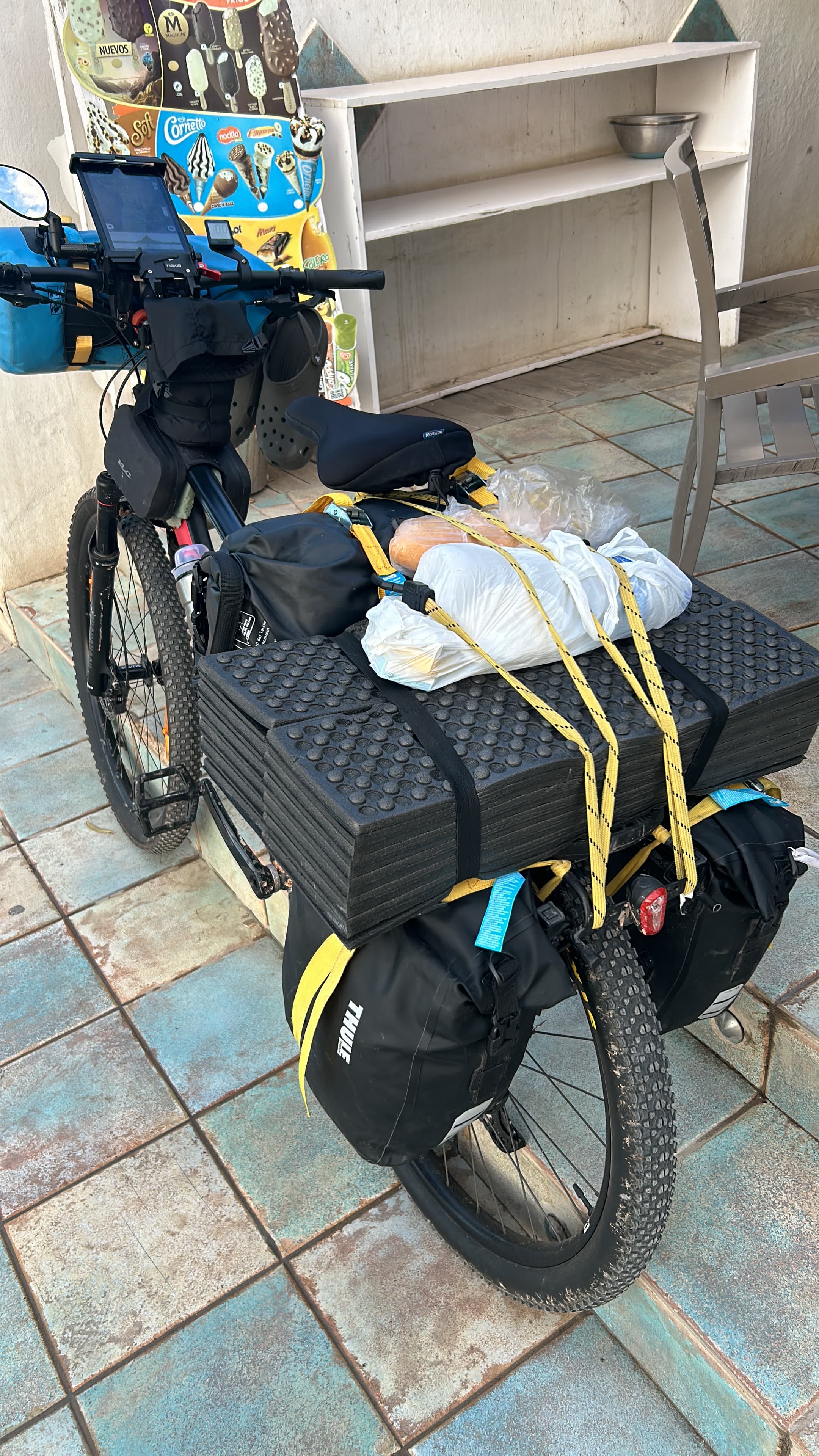 Loaded bicycle with food and gear strapped over the panniers