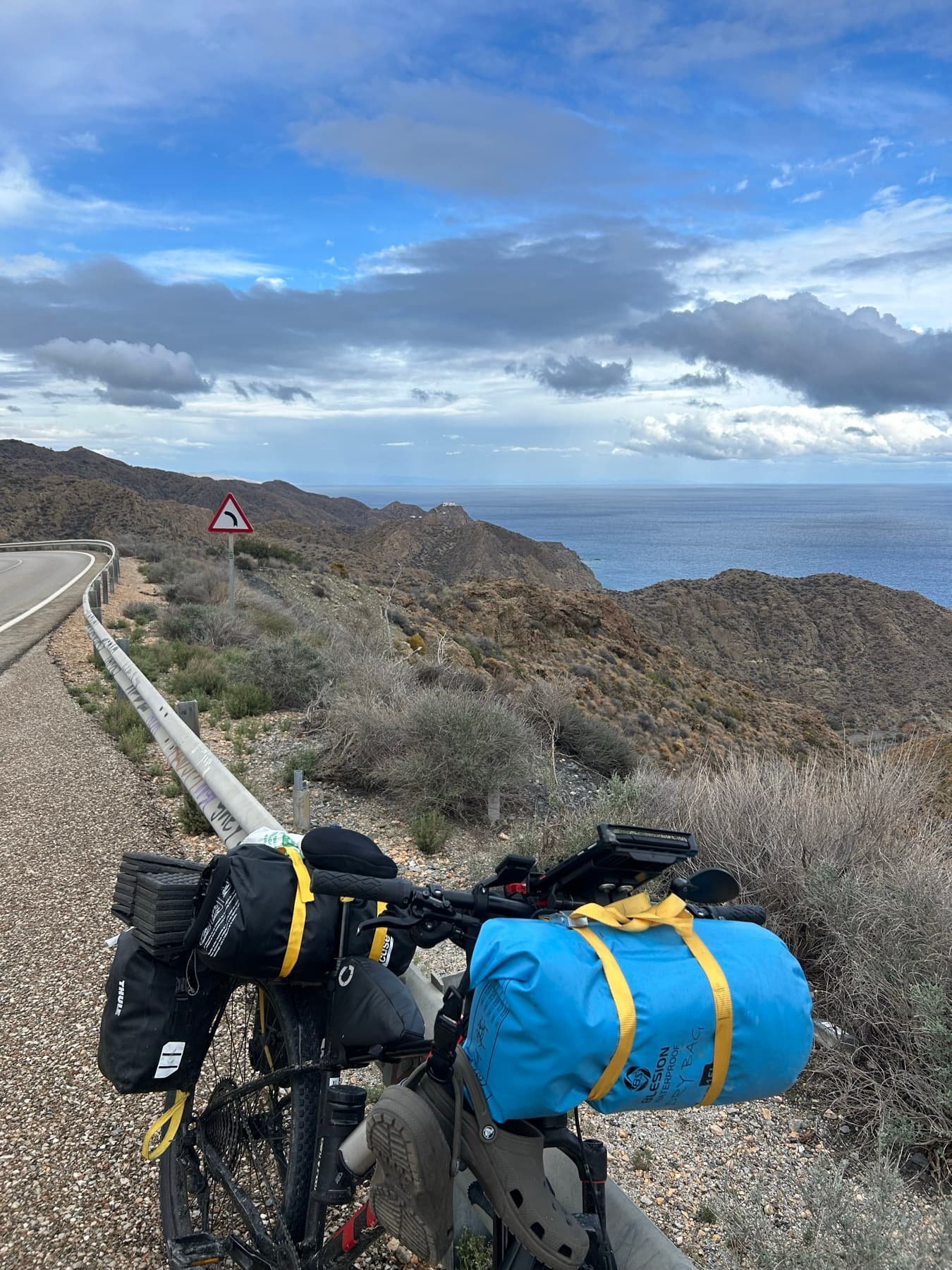 Loaded bicycle on a climbing coastal road