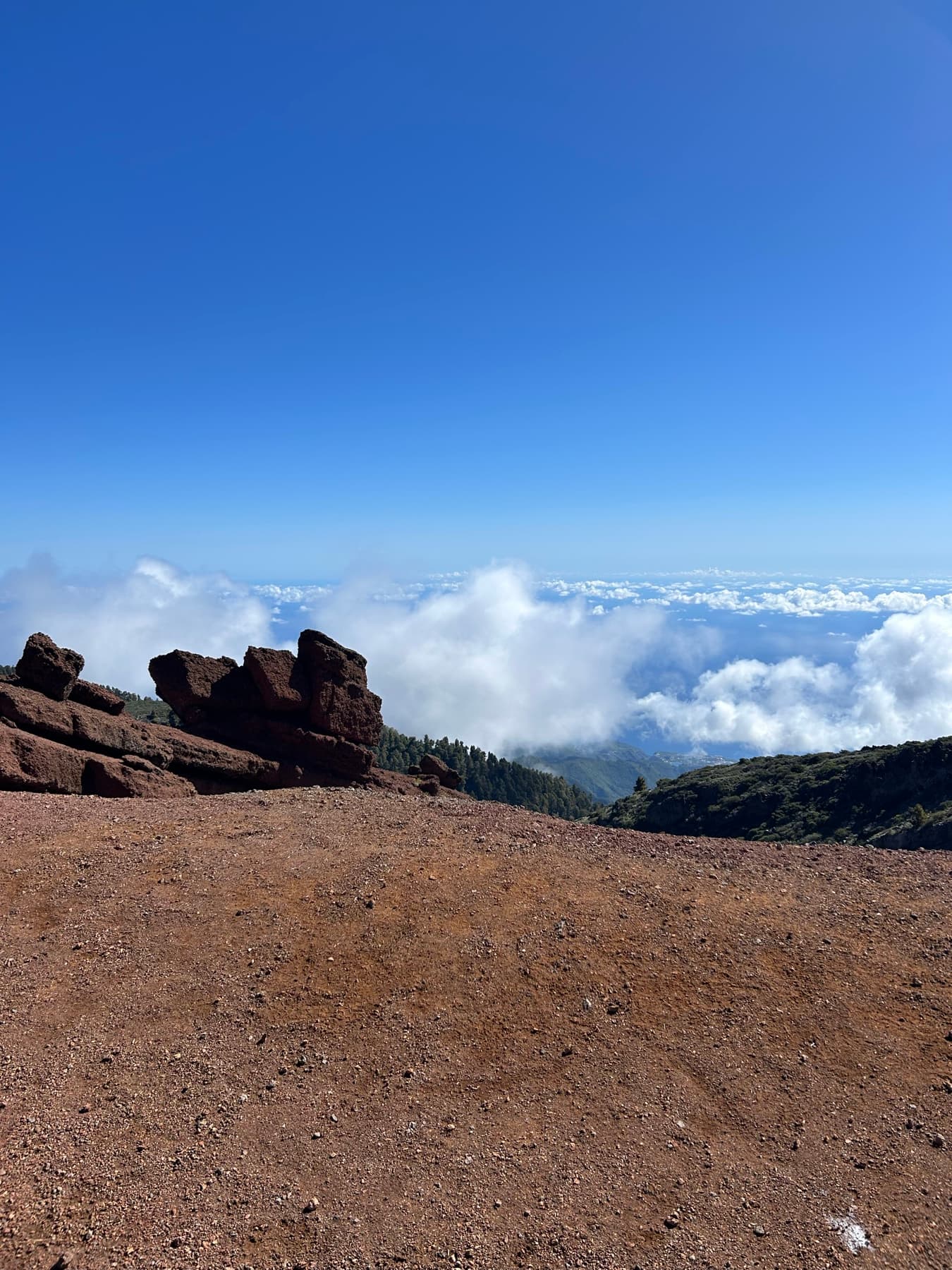 Red volcanic rock above a sea of clouds